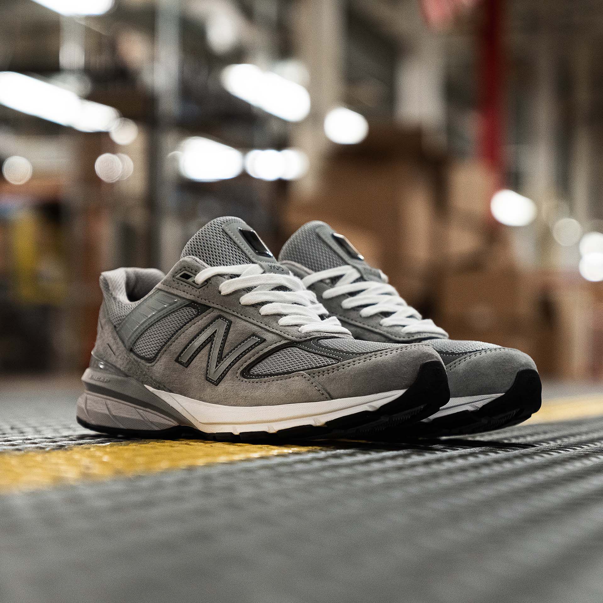 Paire de 990v5 MADE in USA grise posée sur le sol d’une usine